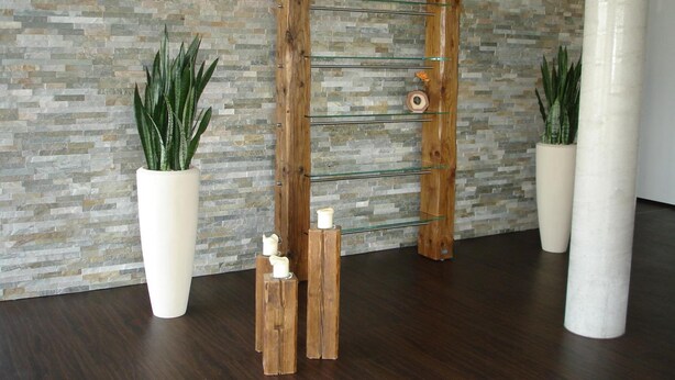 A wooden rack with candles and potted plants against a stone wall. - Hotel Sentio (Voehringen)
