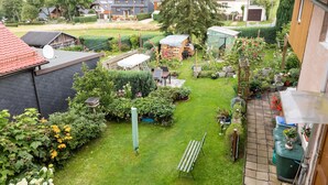 A well-maintained garden with a variety of plants and a small wooden structure.