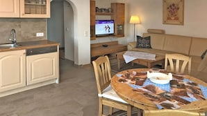 Un espacio habitable compacto con cocina, comedor y zona de estar.