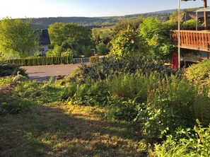 A rural landscape with a house, a fenced area, and a view of the countryside.