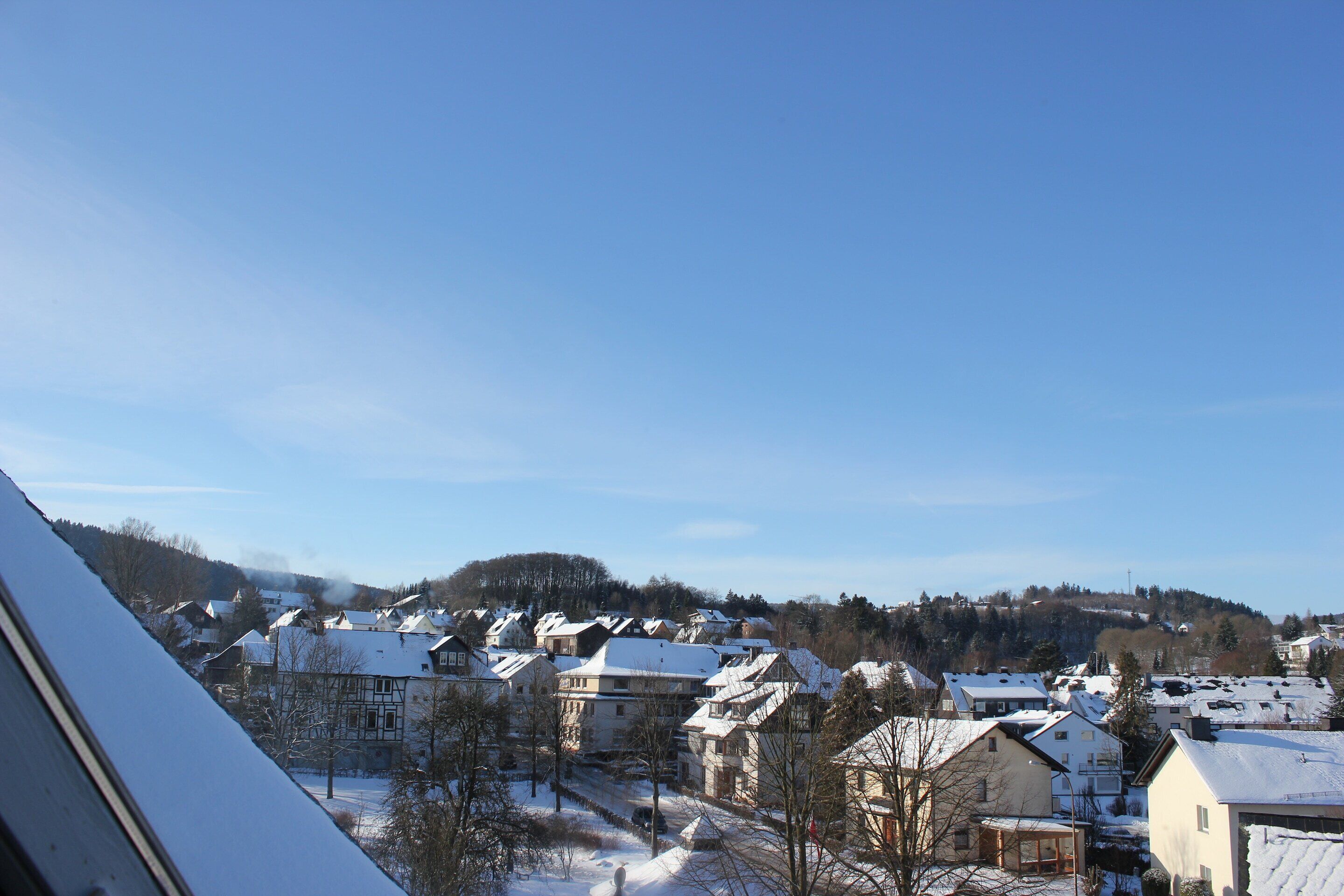 Un quartiere residenziale con case innevate e cielo sereno.