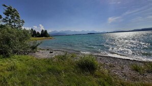 Ein See mit blauem Himmel und Bergen im Hintergrund.