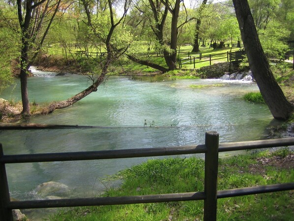A river flowing through a park with a wooden fence in the foreground. - Cozy Cottage in Abbateggio With Garden (Abbateggio)