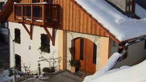 A wooden chalet with a balcony, a door, and a window. - Quaint Farmhouse in Langenbach near Lake (Schleusegrund)