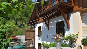 A traditional chalet with wooden beams, a stone well, and a parked car. - Quaint Farmhouse in Langenbach near Lake (Schleusegrund)