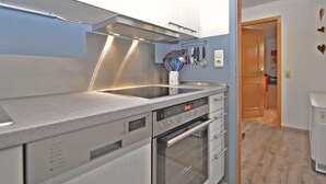 A modern kitchen with stainless steel appliances, a built-in oven, and a range hood. - Holiday Home With Terrace (Stadlern)