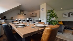 A modern dining area with a wooden table set for six, surrounded by leather chairs. - Apartment in Eibergen Near Zwillbrocker Venn (Eibergen)