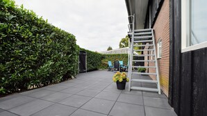 A patio with a black fence, a white ladder, and a potted plant. - Apartment in Eibergen Near Zwillbrocker Venn (Eibergen)