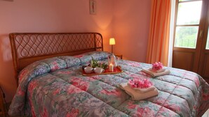 A bed with floral bedding, a tray with tea cups and a teapot, and a lamp on the side. - Belvilla by Oyo Sorano (Sorano)