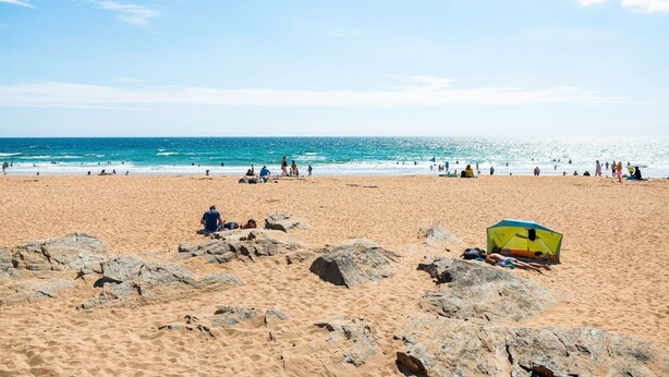 A beach with people, a tent, and large rocks. - Ancienne Gendarmerie With Sea Views (Clohars-Carnoët)
