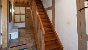 A wooden staircase with a handrail leading to a door at the top. The floor is tiled with a mix of stone and wood patterns. - Superb Holiday Home in Weissenburg near Forest (Weissenburg in Bayern)