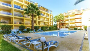A hotel with a swimming pool, sun loungers, and palm trees. - C15- The Patio de Convent Apartment (Lagos)