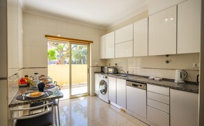 Une cuisine moderne avec un coin repas, un lave-linge et une machine à café.