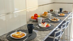 A breakfast buffet setup with various food items and utensils. - C15- The Patio de Convent Apartment (Lagos)