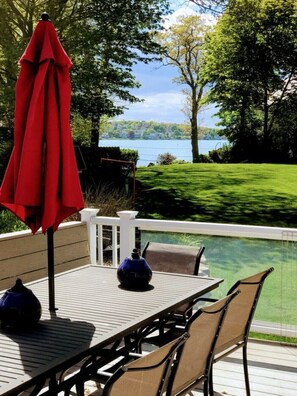 A deck with a table and chairs, overlooking a lake. - Hingham Harbor Retreat ~ Sunsets ~ Family Gatherings ~ Trails at World’s End (Hingham,)