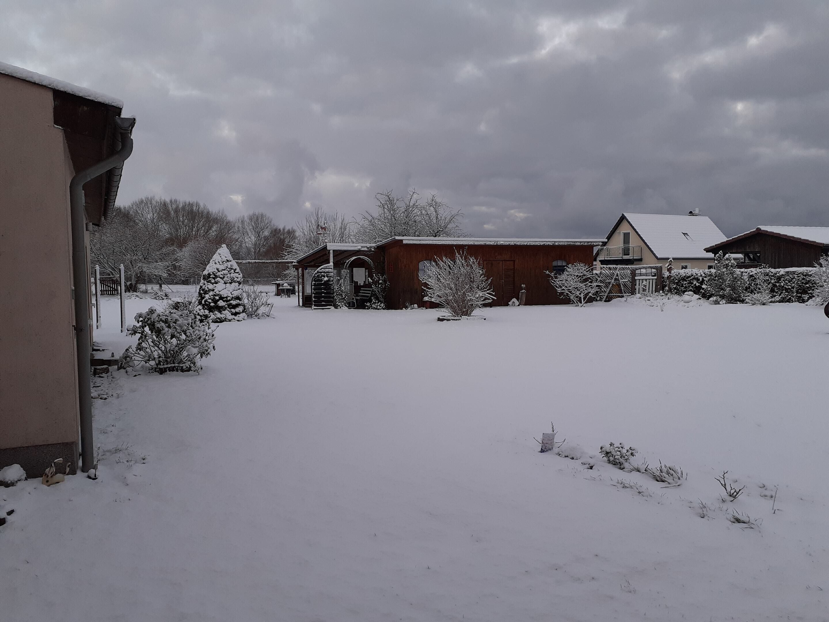 Un quartier résidentiel enneigé, avec des maisons et un chalet en bois.