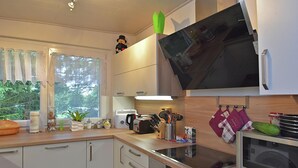 Ett modernt kök med vita skåp, en mikrovågsugn, en brödrost och ett handfat.