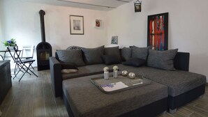 Un salon moderne avec un canapé d’angle, une cheminée et un coin repas comprenant une table et des chaises.