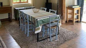 A dining area with a table set for six, wooden chairs, a woven basket, and a rustic ceiling. - Countryside Stay in Fransu (Fransu)