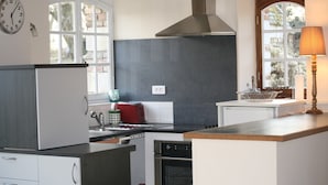 A kitchen with a stove, oven, and a clock on the wall. - Countryside Stay in Fransu (Fransu)