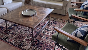 A living room with two sofas, a coffee table, a patterned rug, a wooden chair, and a window with curtains. - Countryside Stay in Fransu (Fransu)