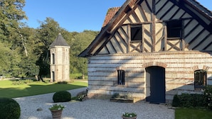 A traditional half-timbered house with a tower, gravel driveway, and potted plants. - Countryside Stay in Fransu (Fransu)