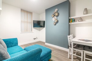 Apartamento empresarial, 1 quarto, no piso térreo (Bottom) | Sala de estar | TV de tela plana 42 polegadas com canais digitais, TV