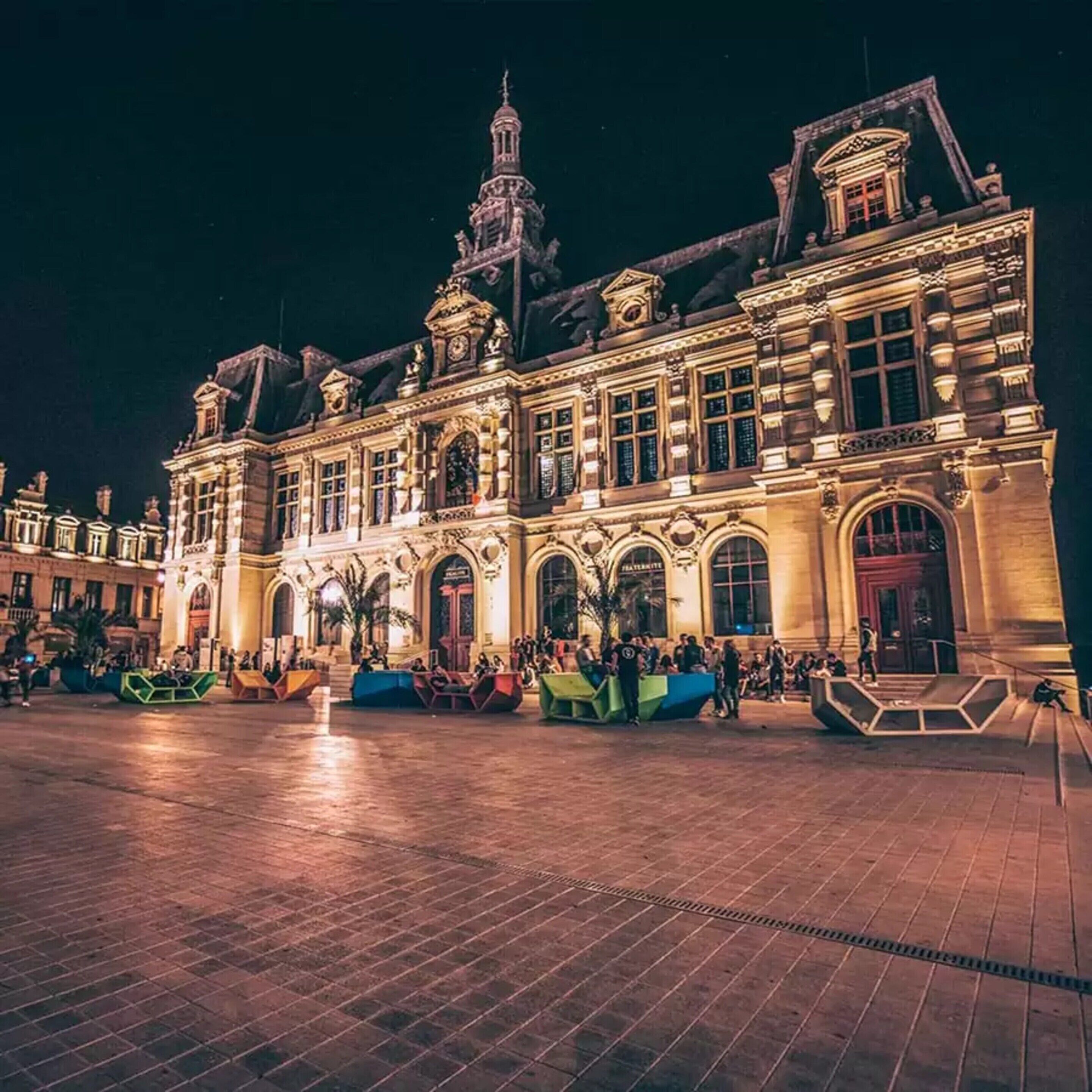 Een historisch gebouw met versierde architectuur, grote ramen en een centrale ingang.