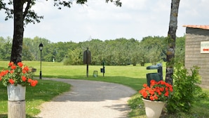 A gravel path leading to a wooden structure labeled 'RECEPTION' with a sign indicating a left turn. - Villa in Les Forges With Golf Access (Les Forges)