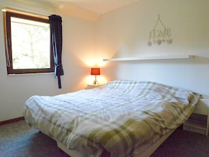 A bedroom with a bed, a window with curtains, a bedside lamp, and a wall-mounted decoration. - Spacious House With Beautiful Terrace (Hastiere)