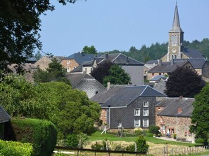 A village with stone buildings, a church with a steeple, and a well-maintained lawn. - Spacious House With Beautiful Terrace (Hastiere)