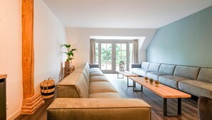 A modern living room with a sofa set, a wooden coffee table, and a fireplace. - Spacious Farmhouse With Sauna, Hottub (Noardburgum)