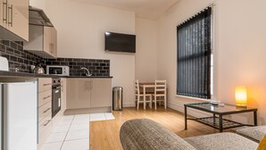 A compact living space with a kitchenette, a dining area, and a seating area with a table and chairs. - Platform Fishing Quarter Apartments (Hull)