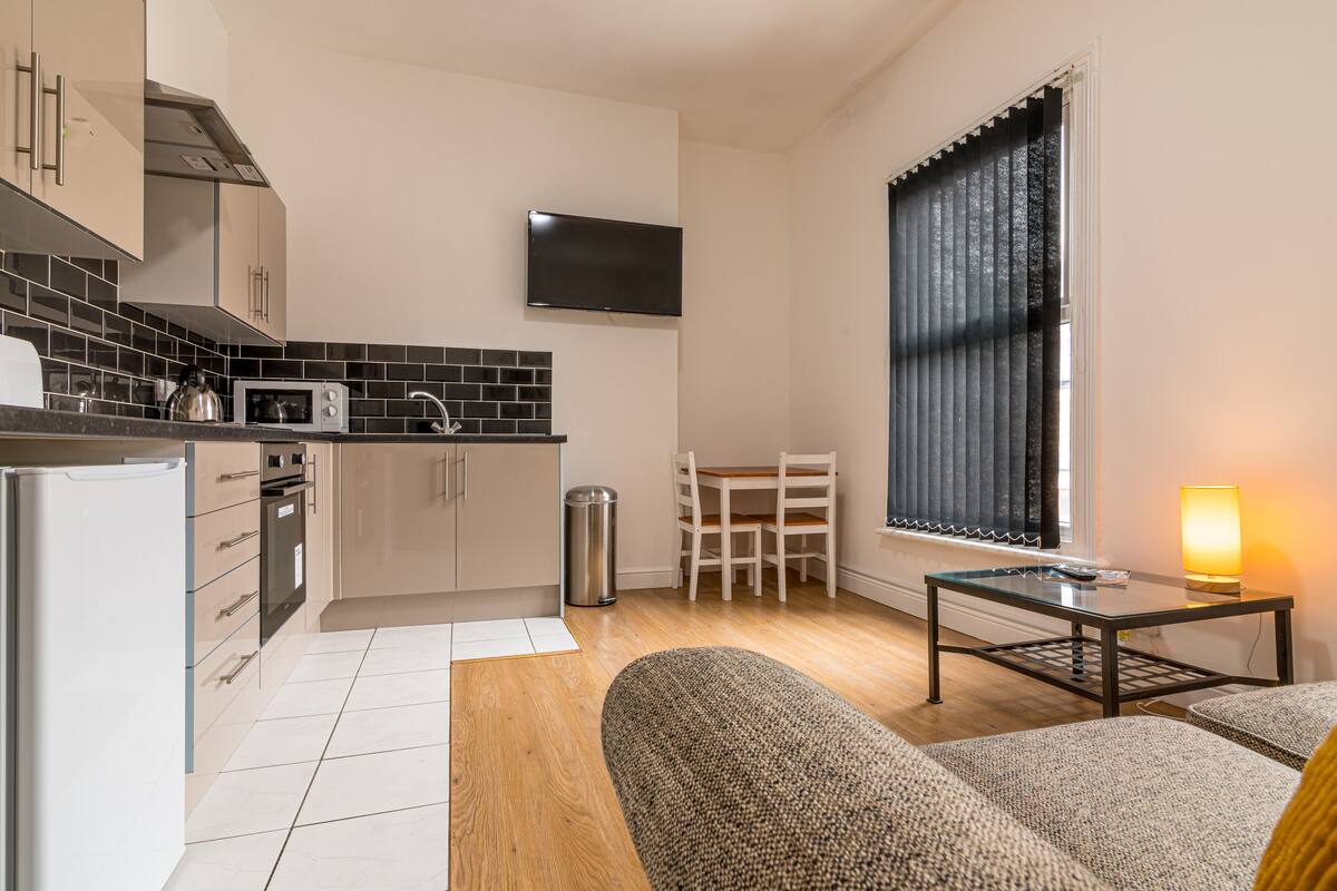 A compact living space with a kitchenette, a dining area, and a seating area with a table and chairs.