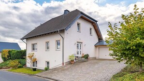 Et toetagers hus med skråtag, en veranda og en garage.