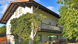 A two-story house with a balcony, a small garden, and outdoor seating. - Tranquil Garden Apartment (Regen)