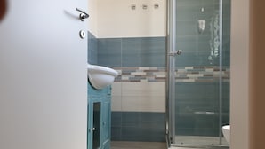 A bathroom with a toilet, a sink, and a shower. - Caletta sul Mare (Siniscola)