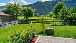 A rural landscape with a wooden fence, a stone pathway, and a grassy field. - Cosy Apartment in Muhlbach With Balcony (Bramberg am Wildkogel)