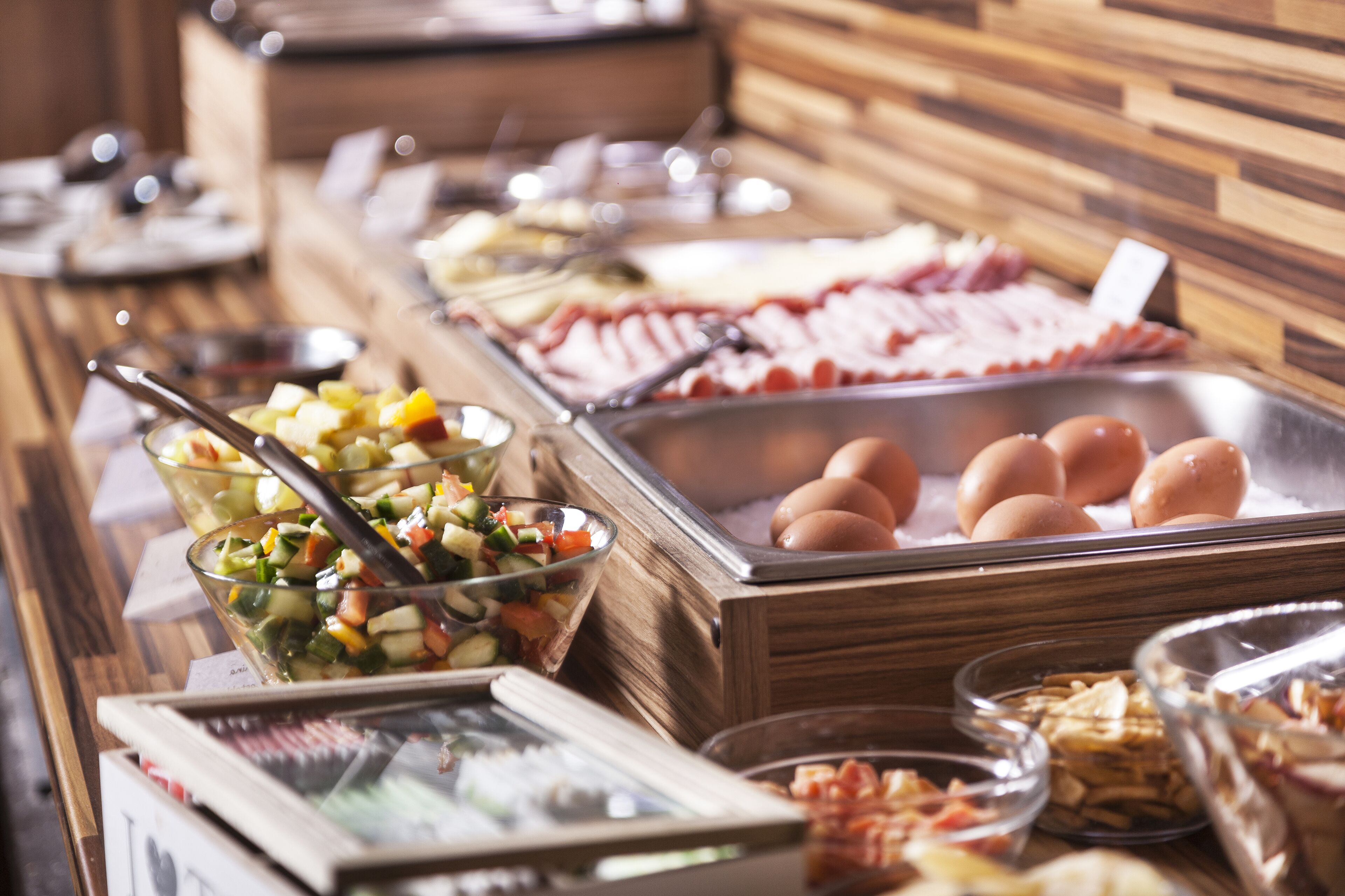 A buffet with various food options including fruits, vegetables, eggs, and meats.