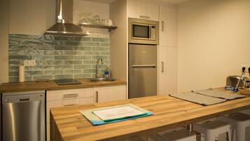 Una cucina moderna con lavastoviglie in acciaio inox, un forno a microonde e un forno doppio.