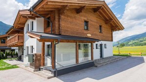 Una casa moderna a due piani con facciata in legno, ampie vetrate e un balcone.