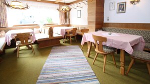 A cozy restaurant with wooden furniture, a green carpet, and a rustic interior. - Apartment in Niedernsill Near Zell am See Ski Area (Niedernsill)