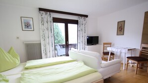 A bedroom with a bed, a television, a table, and a chair. - Apartment in Niedernsill Near Zell am See Ski Area (Niedernsill)