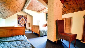 A room with a wooden ceiling, a bed, a chair, a wall tapestry, and a brick wall. - Comfortable Villa, Paliseul (Paliseul)