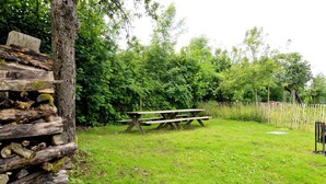 A picnic area with a wooden bench and a stack of firewood. - Comfortable Villa, Paliseul (Paliseul)