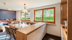 Una cocina moderna con una isla central, ventanas amplias y vistas a zonas verdes.