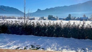 A snowy landscape with a clear sky, mountains in the background, and a few buildings. - Cozy Alpine Flat in Altenau (Saulgrub)