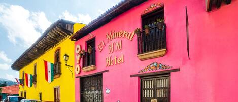 Un edificio de colores vivos con un letrero que dice "El Mineral Hotel".