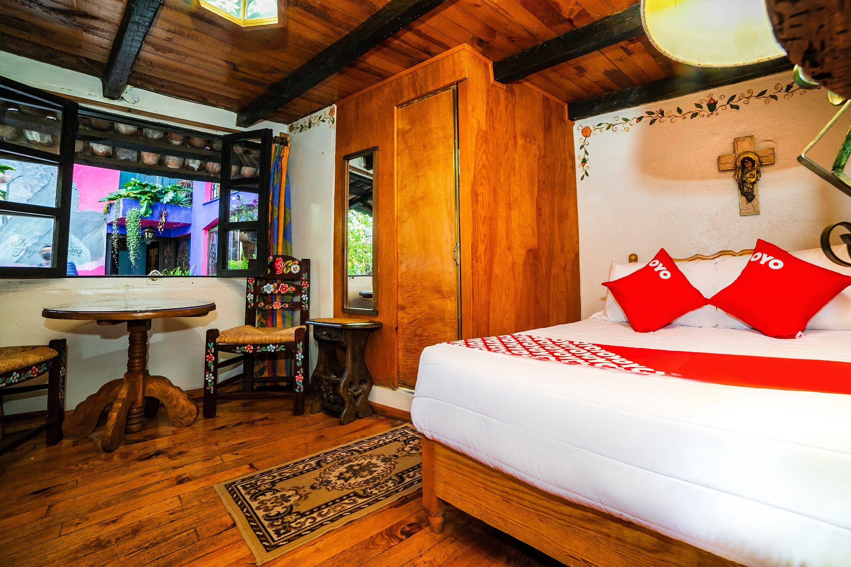 A wooden room with a bed, a table, and chairs.