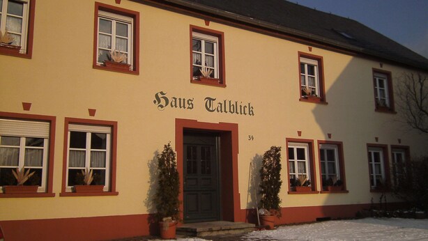 A building with the name "Hans Talblick" on the facade, featuring multiple windows and a door, surrounded by snow. - Apartment in Morbach Near Ski Lift (Morbach)